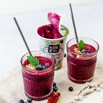 Becher von Hafer-Joghurtalternative Heidelbeere und Joghurt in Gläsern dekoriert