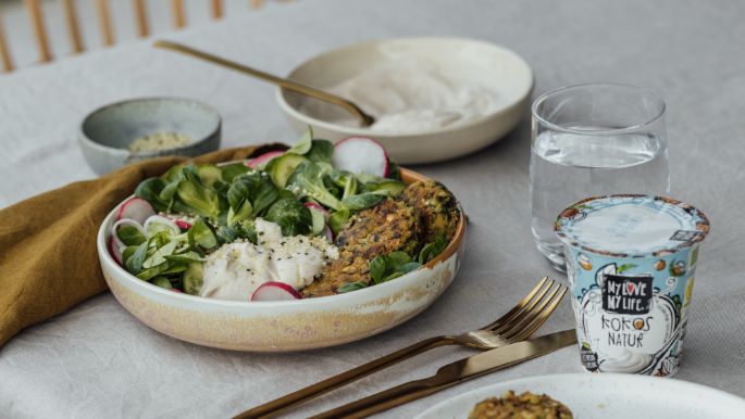 Spinat Falafel mit Feldsalat, Radieschen und Creme in Schüssel auf Tisch gedeckt